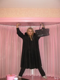 a woman in a black coat holding a black purse